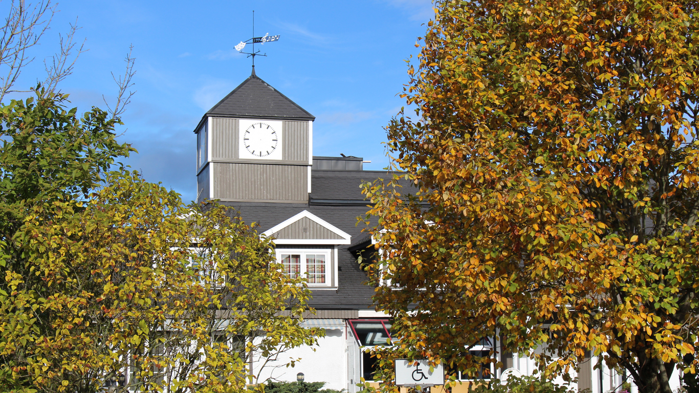 Bilde av klokketårnet på kulturhuset i GJerdrum. Høstløv i forgrunnen.